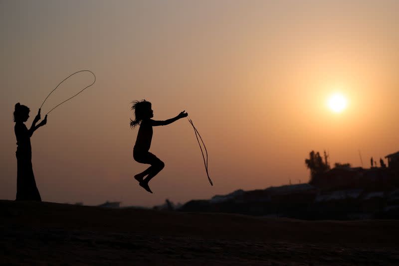 FILE PHOTO: Rohingya refugee children are silhouetted as they play with jumping ropes at Balukhali camp in Cox’s Bazar