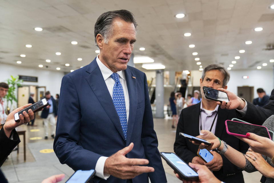 Sen. Mitt Romney, R-Utah, speaks to reporters as he walks on the Senate subway on Capitol Hill, Tuesday, June 8, 2021, in Washington. (AP Photo/Manuel Balce Ceneta)