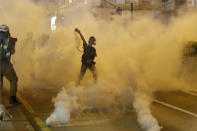 FILE - In this Aug. 3, 2019, file photo, a protester throws back a tear gas canister during a confrontation with police in Hong Kong. Many in Hong Kong took to the streets in 2019 hoping to salvage rights of free speech and association denied to residents of mainland China, where public dissent is treated as subversive and punishable by long prison terms. (AP Photo/Vincent Thian, File)