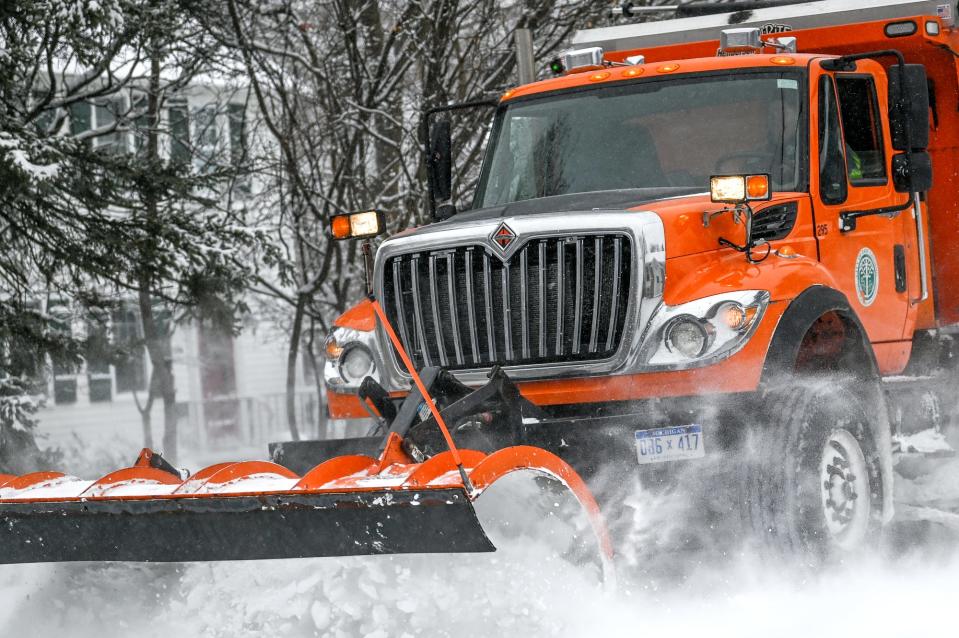 A city truck clears a road in a residential neighborhood on Friday, Dec. 23, 2022, in East Lansing.