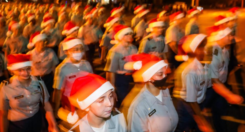 Membrers of the West Port High School ROTC march with festive Santa hats in the Ocala Christmas Parade Saturday. This year marked the 65th annual Ocala Christmas Parade which was cancelled last year due to the pandemic. The theme this year was "A Hero's Christmas." The parade took place Saturday night, December 11, 2021, beginning at 5:30 at the intersection of SE 25 Ave and E Fort King St. The procession headed north and turned left on east Silver Springs Blvd. It will go for roughly three miles and end just before hitting Tuscawilla park on NE 8th Avenue. Nearly 100 floats, bands and dance troupes took part in the holiday event.  [Doug Engle/Ocala Star-Banner]2021