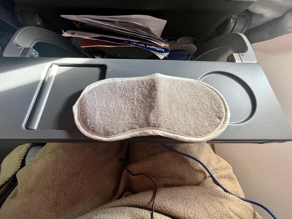 The eyemask sitting on the tray table.