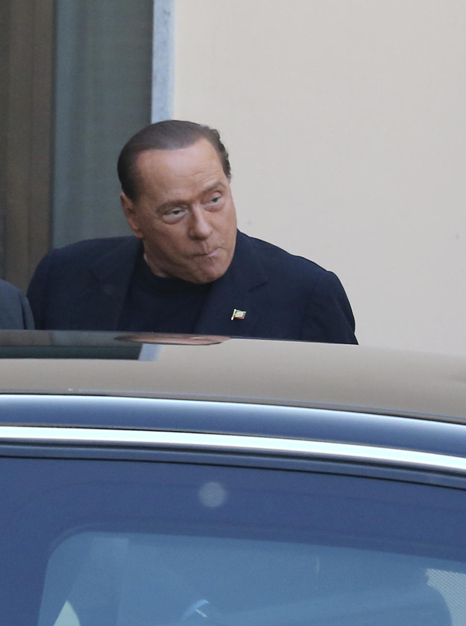 Former Italian premier Silvio Berlusconi, right, arrives at the "Sacra Famiglia" foundation in Cesano Boscone, near Milan, Italy, to carry out a court order to help the elderly, Friday, May 9, 2014. Berlusconi will help patients with Alzheimer disease for four hours per week as part of his punishment for tax fraud conviction. (AP Photo/Antonio Calanni)