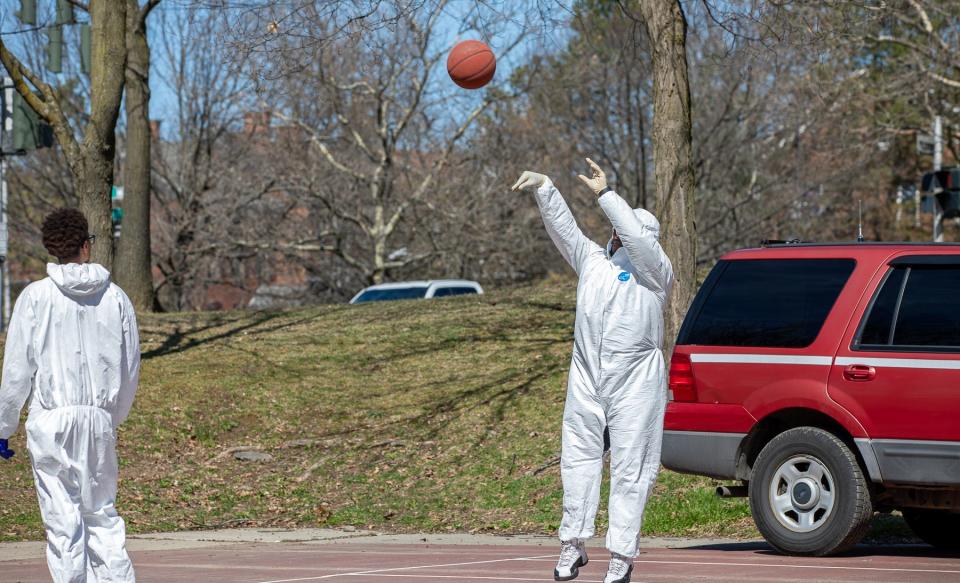 DJ Huggan fires a jump shot during a March 21 pickup basketball game in the City of Poughkeepsie. He and six friends played while wearing Hazmat suits.