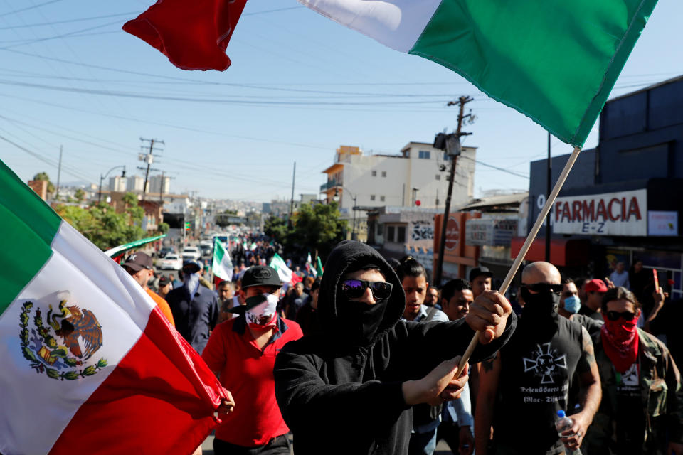 Demonstrators wave Mexican flags during a protest against migrants who are part of a caravan traveling en route to the United States, in Tijuana, Mexico, on Nov. 18, 2018. (Photo: Carlos Garcia Rawlins / Reuters)