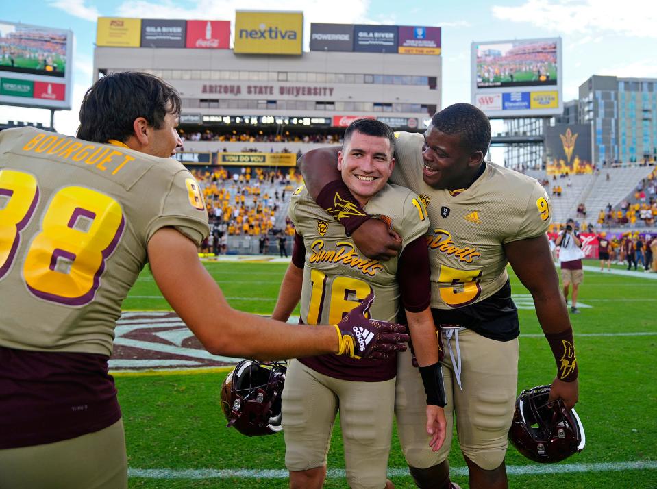 ASU wide reciever Coben Bourguet (88) and defensive lineman Robby Harrison (93) celebrate with ASU quarterback Trenton Bourguet (16) after an 45-38 upset win over Washington at Sun Devil Stadium in Tempe on Oct. 8, 2022.