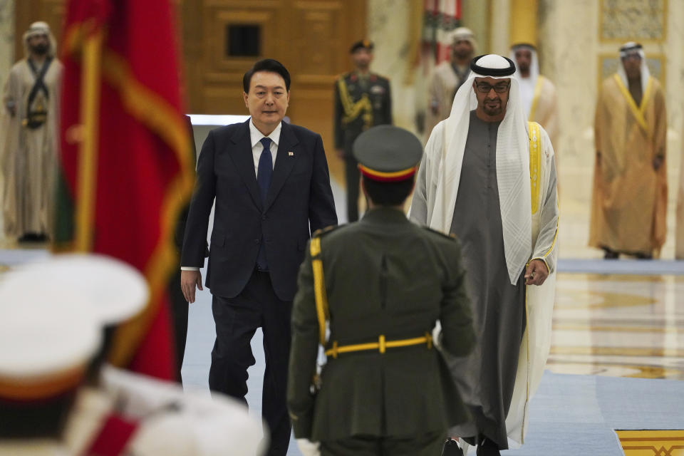 South Korean President Yoon Suk Yeol, center left, and Emirati leader Sheikh Mohammed bin Zayed Al Nahyan walk past an honor guard at Qasar Al Watan in Abu Dhabi, United Arab Emirates, Sunday, Jan. 15, 2023. Yoon received an honor guard welcome Sunday on a trip to the United Arab Emirates, where Seoul hopes to expand its military sales while finishing its construction of the Arabian Peninsula's first nuclear power plant. (AP Photo/Jon Gambrell)