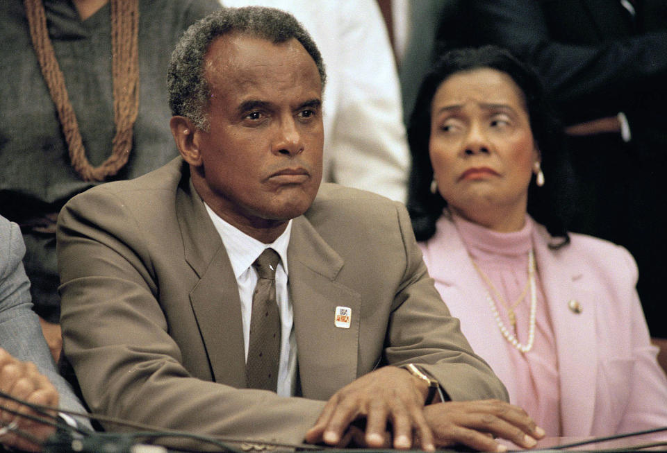 FILE - Entertainer and activist Harry Belafonte, and Coretta Scott King, widow of slain civil rights leader Dr. Martin Luther King, Jr., listen to a speaker during an anti-apartheid demonstration on Capitol Hill in Washington on Aug. 12, 1985. Belafonte died Tuesday of congestive heart failure at his New York home. He was 96. (AP Photo/Lana Harris, File)