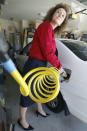 Connie Jones connects the nozzle of a home refueling station to her 2003 natural gas powered Honda Civic in the garage of her home in Chandler, Arizona, October 3, 2013. (REUTERS/Ralph D. Freso)