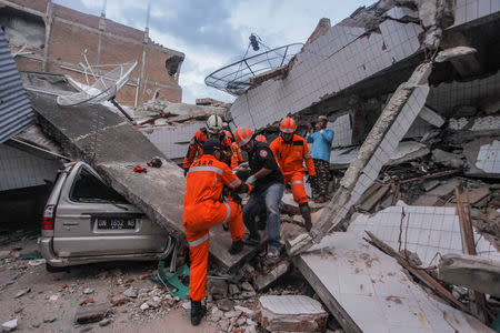 Search and rescue workers evacuate an earthquake and tsunami survivor trapped in a collapsed restaurant, in Palu, Central Sulawesi. Antara Foto/Muhammad Adimaja/ via REUTERS