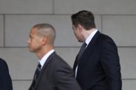 Elon Musk walks with his face turned away from cameras as he arrives at court for trial in Los Angeles