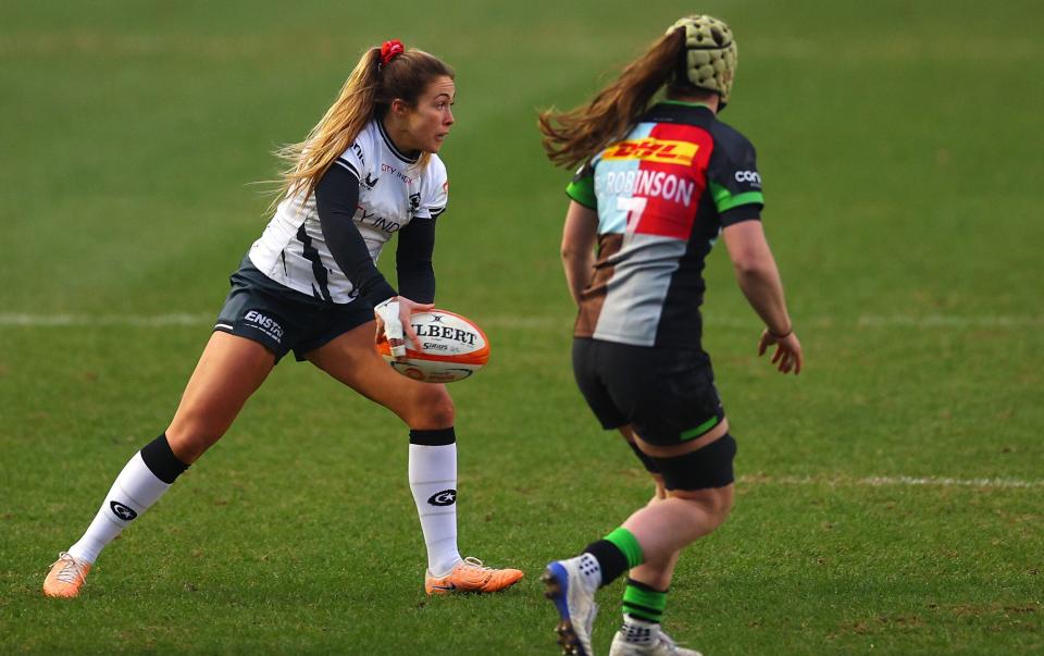 Sydney Gregson of Saracens Women looks to pass the ball whilst under pressure from Emily Robinson of Harlequins Women during the Allianz Premiership Women's Rugby match between Harlequins and Saracens