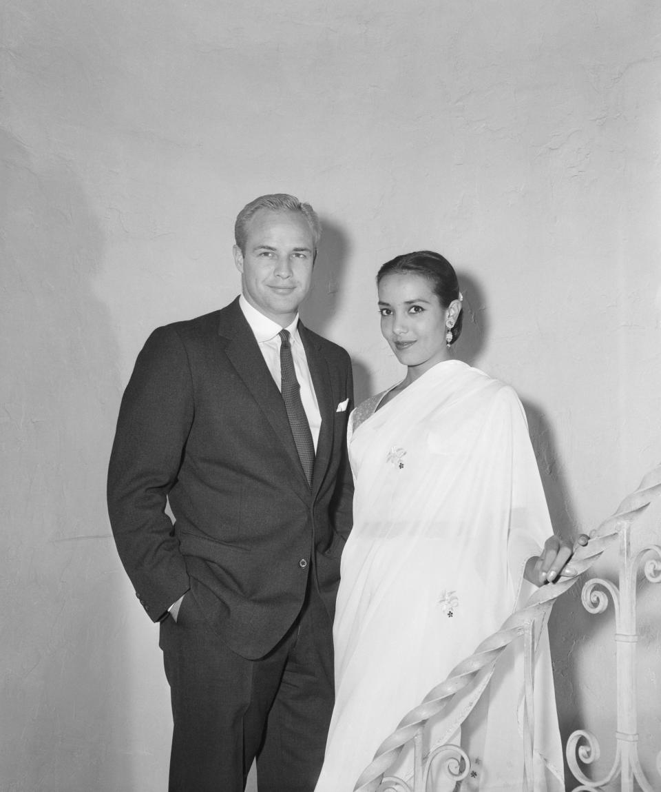 Marlon Brando poses in a suit with Anna Kashfi in a white sari.