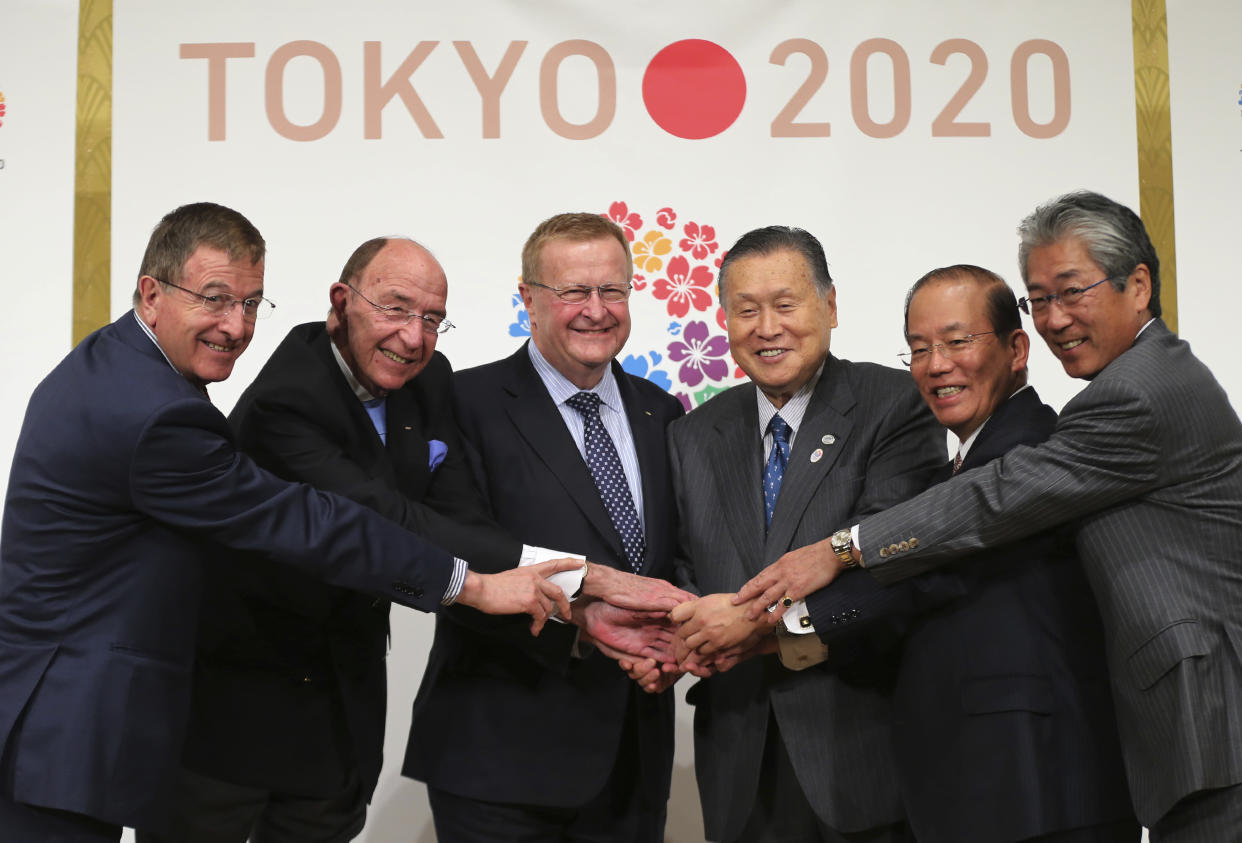 FILE - In this April 4, 2014, file photo, From left, then International Olympic Committee (IOC) Executive Director Gilbert Felli, IOC member Alex Gilady, IOC Vice President John Coates, Yoshiro Mori, president of the Tokyo Organizing Committee of the Olympic and Paralympic Games, Toshiro Muto, Chief Executive Officer of Tokyo 2020, and then Japan's Olympic supremo Tsunekazu Takeda pose for photographers at IOC/ TOKYO 2020 Joint Press Conference in Tokyo. Mori resigned Friday, Feb. 12, 2021 as the president of the Tokyo Olympic organizing committee following sexist comments implying women talk too much. (AP Photo/Eugene Hoshiko, File)