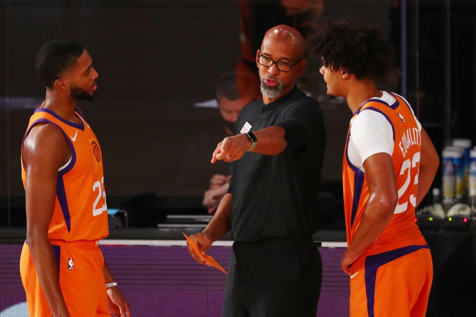 Jul 31, 2020; Lake Buena Vista, Florida, USA;  Phoenix Suns head coach Monty Williams talks with forward Cameron Johnson (23) and forward Mikal Bridges (25) against the Washington Wizards in the second half of a NBA basketball game in the Visa Athletic Center at the ESPN Wide World of Sports Complex. Mandatory Credit: Kim Klement-USA TODAY Sports