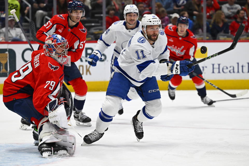 Tampa Bay Lightning center Luke Glendening (11) attempts to bat the puck toward Washington Capitals goaltender Charlie Lindgren (79) during the first period of an NHL hockey game Saturday, April 13, 2024, in Washington. (AP Photo/John McDonnell)