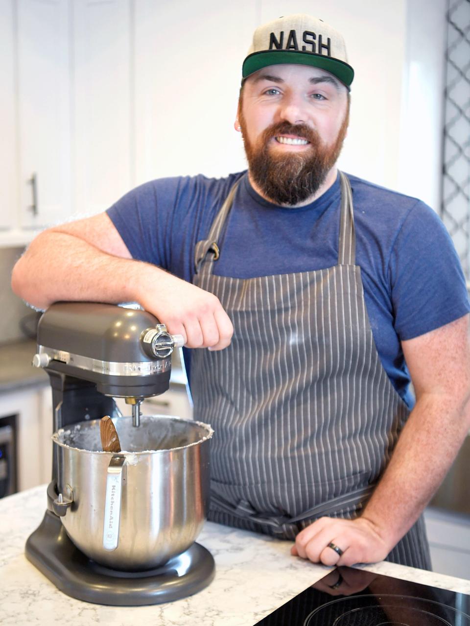 Signature Desserts co-owner and baker Nate Clingman decorates a cake for a customer in his Nolensville, Tennessee, home on Friday.