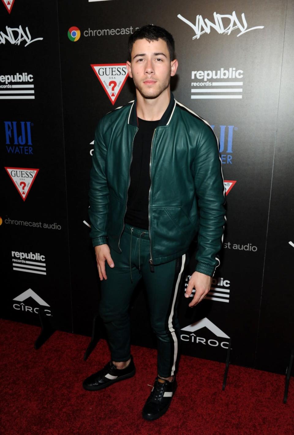 <p>Nick Jonas turned out post-VMAs rocking a green bomber jacket with a black-and-white stripe at the side and matching pants. (Photo: Getty Images)</p>