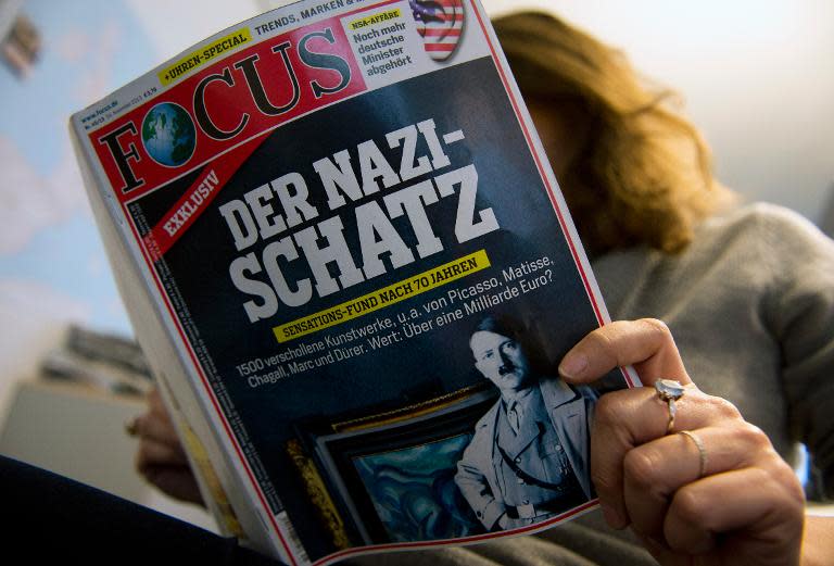 A journalist reads an issue of the German weekly magazine Focus featuring the story of re-discovered artworks stolen by the Nazis, in Berlin on November 4, 2013