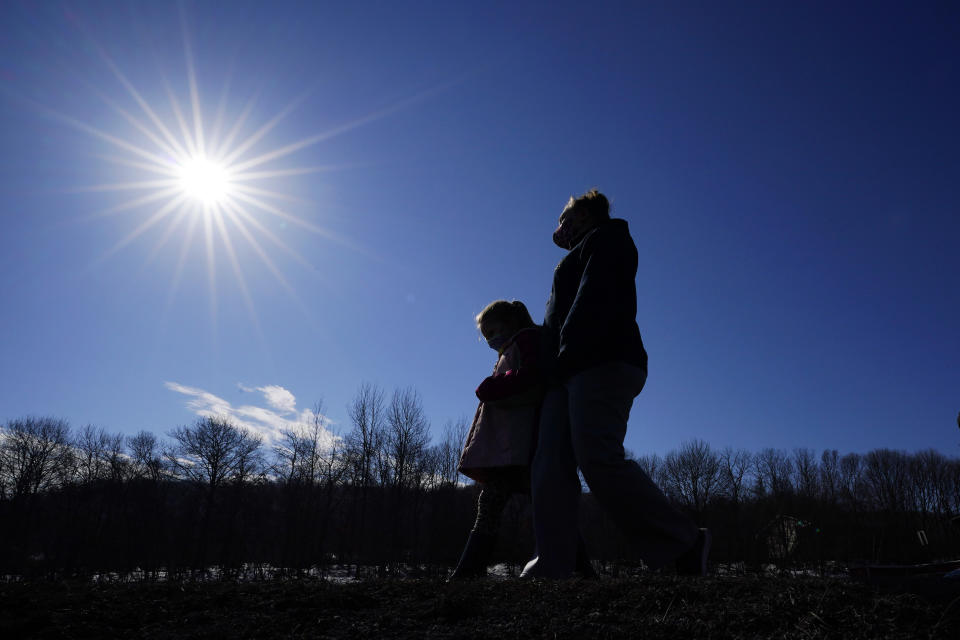 Kacie Thompson, left, 9, walks with her mother, Melissa Weirich, after visiting the former home of Kacie's friend, Ava Lerario, Thursday, March 11, 2021, in Lansford, Pa. On May 26, 2020, 9-year-old Ava; her mother, Ashley Belson, and Ava's father, Marc Lerario, were found fatally shot. (AP Photo/Matt Slocum)