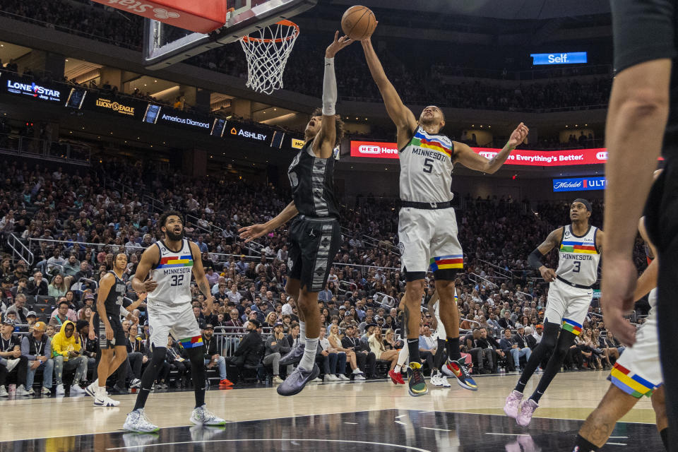 San Antonio Spurs forward Dominick Barlow, center left, and Minnesota Timberwolves forward Kyle Anderson (5) reach for a rebound during the second half of an NBA basketball game, Saturday, April 8, 2023, in Austin, Texas. (AP Photo/Stephen Spillman)