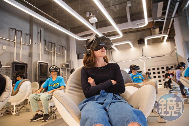 科幻風格的VR體感劇院內，觀眾可以戴上頭戴式顯示設備、坐在圓弧形蛋椅上觀賞。