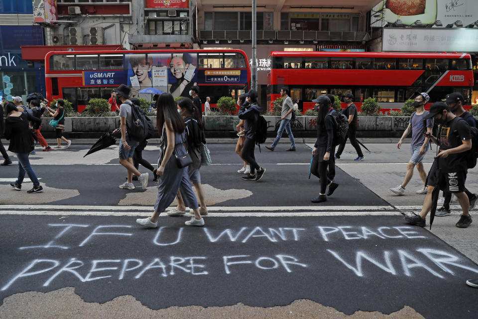 Protesters wearing face mask walk on a road during a protest in Hong Kong, Saturday, Oct. 12, 2019. The protests that started in June over a now-shelved extradition bill have since snowballed into an anti-China campaign amid anger over what many view as Beijing's interference in Hong Kong's autonomy that was granted when the former British colony returned to Chinese rule in 1997. (AP Photo/Kin Cheung)