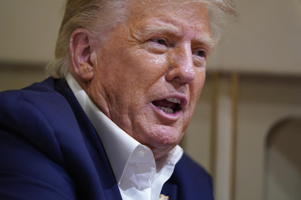 Former President Donald Trump speaks with reporters while in flight on his plane after a campaign rally at Waco Regional Airport, in Waco, Texas, Saturday, March 25, 2023, while en route to West Palm Beach, Fla. (AP Photo/Evan Vucci)