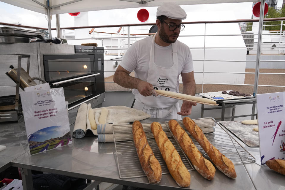 El panadero francés Tony Dore prepara baguettes como las que les ofrecerán a los deportistas durante los Juegos Olímpicos de París el martes 30 de abril del 2024. (AP Foto/Michel Euler)