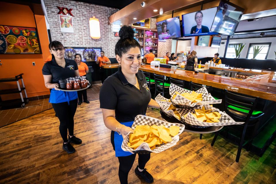 El Rodeo Tequila Bar and Grill held its grand opening Friday on Thomas Drive in Panama City Beach. Servers Elsy Alfaro, right, and Grismalyin Vargas bring out the first orders of chips and salsa to customers after opening.