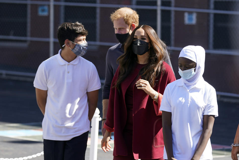 Prince Harry and Meghan, the Duke and Duchess of Sussex walk with students during their visit to P.S. 123, the Mahalia Jackson School, in New York's Harlem neighborhood, Friday, Sept. 24, 2021. (AP Photo/Richard Drew)