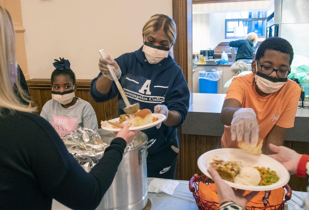 Diel Stewart serves gravy while volunteering with her children Brielle, 7, left, and Brycen, 11, right, at the Bishop's 62nd Annual Thanksgiving Dinner at St. Paul's Cathedral in 2021.