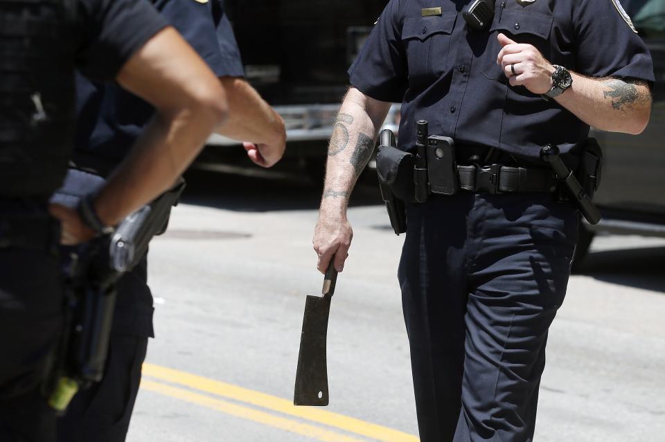 A police officer holds a cleaver after a man was detained outside federal court in Boston. (Michael Dwyer/AP)