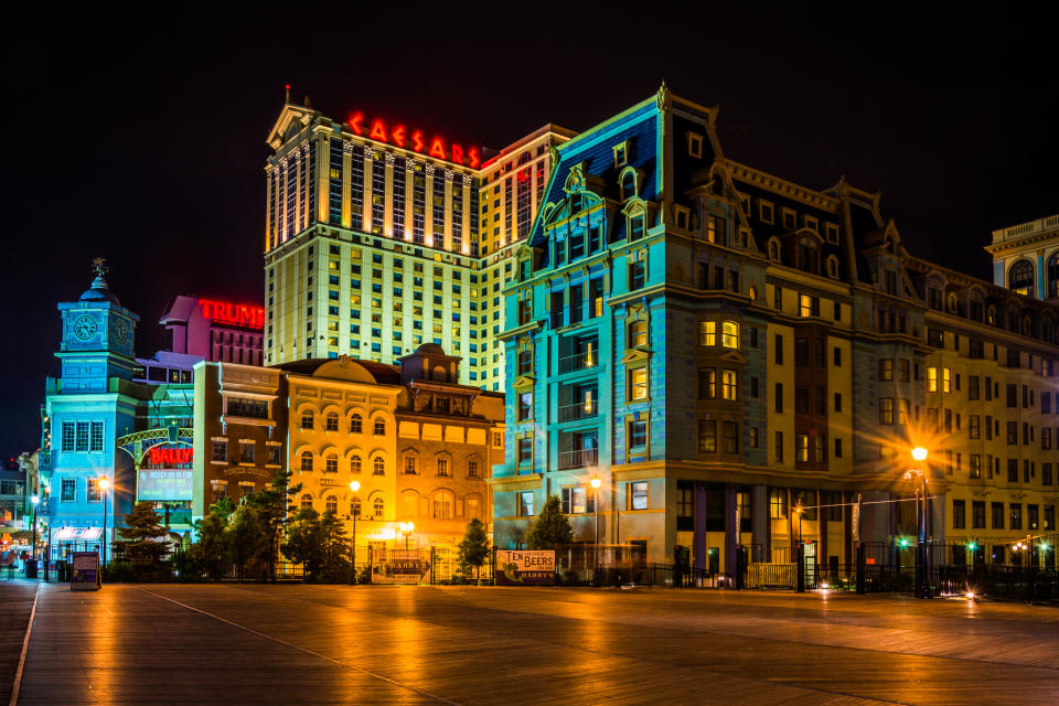 Nighttime view of the Caesar's and Trump Plaza buildings with illuminated signage