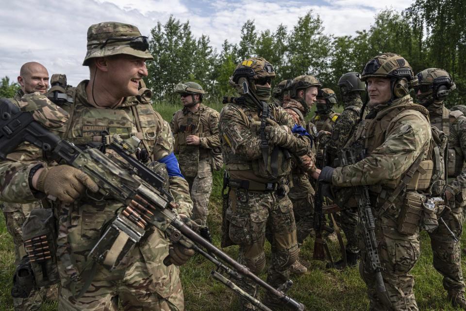 Russian Volunteer Corps fighters gather for a break after a news conference near the Russian-Ukraine border in May 2023. (AP Photo/Evgeniy Maloletka)