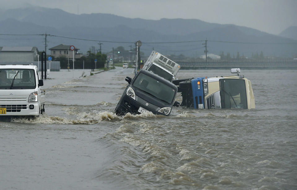 Cars are overturned in rice fields in Tachiarai in Fukuoka Prefecture, southwestern Japan, due to flooding from the Tachiarai River in Fukuoka Prefecture. Source: AP