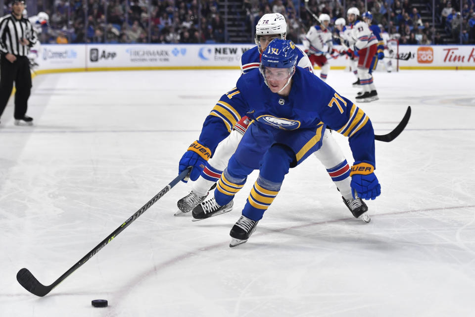 Buffalo Sabres left wing Victor Olofsson, front, reaches for the puck in front of New York Rangers center Filip Chytil during the first period of an NHL hockey game in Buffalo, N.Y., Friday, March 31, 2023. (AP Photo/Adrian Kraus)