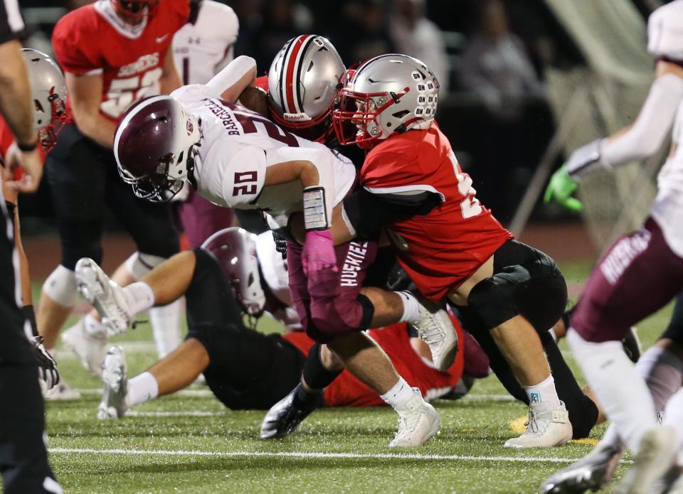 Ryan Cole (right) and a teammate drag down a ball carrier during Somers' 39-7 victory over Harrison in the Section 1 Class A semifinals at Somers High School on Nov. 4, 2022.