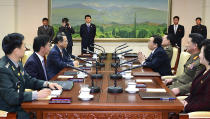 In this photo released by the South Korean Unification Ministry, South Korean chief delegate Kim Kyou-hyun, third from left, talks with his North Korean counterpart Won Tong Yon, third from right, during a meeting at the border village of Panumjom, South Korea, Friday, Feb. 14, 2014. The rival Koreas sat down Friday for a second round of talks this week at a border village as the North's calls for a delay of annual South Korea-U.S. military drills threaten plans for the resumption of emotional reunions of war-divided families. (AP Photo/South Korean Unification Ministry)