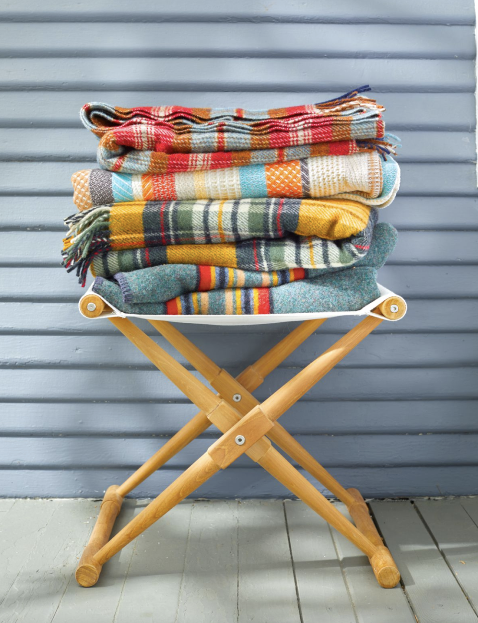 stack of wool blankets resting on a canvas camp stool