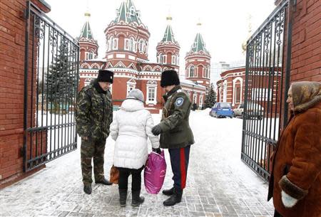 Russian Cossacks, who started regular patrols within the city in the wake of recent suicide attacks, check a woman's belongings in front of the Kazan Orthodox Cathedral in the southern Russian city of Volgograd, January 4, 2014. REUTERS/Vasily Fedosenko