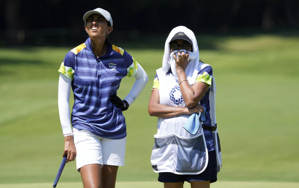 Aditi Ashok, of India, left, speaks with her caddie on the 15th hole during the first round of the women's golf event at the 2020 Summer Olympics, Wednesday, Aug. 4, 2021, at the Kasumigaseki Country Club in Kawagoe, Japan. (AP Photo/Andy Wong)