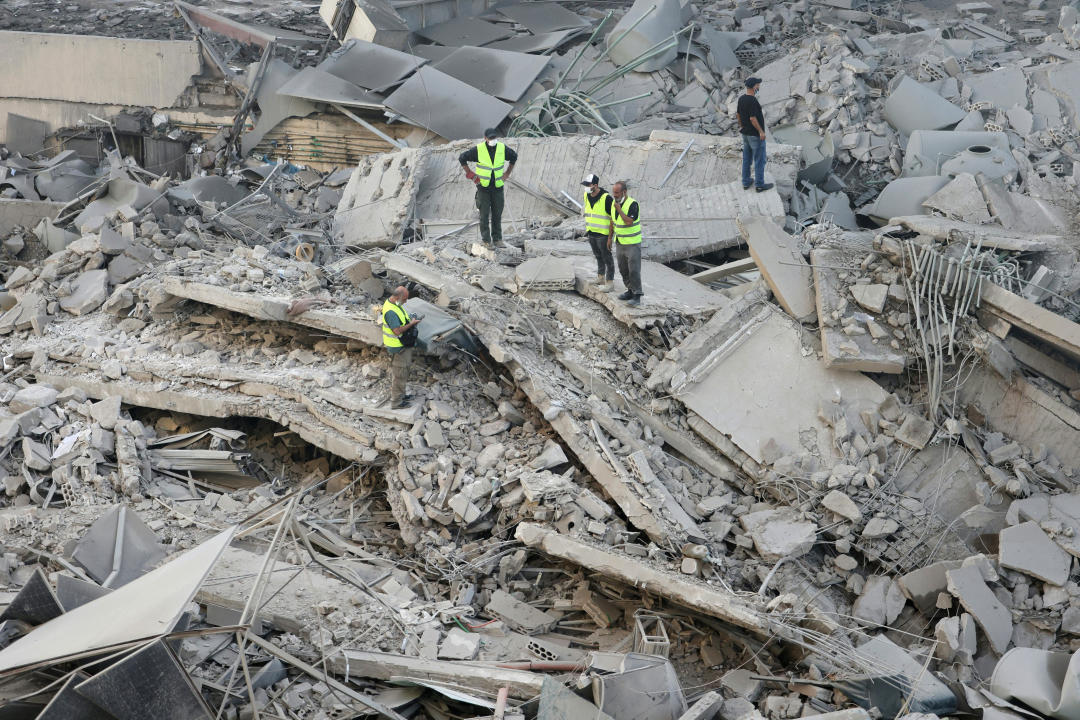 Los rescatistas revisan el lugar de un ataque aéreo israelí nocturno en el suburbio de Shayyah, al sur de Beirut, el 2 de octubre de 2024. Al menos cinco ataques israelíes alcanzaron los suburbios del sur de Beirut a principios del 2 de octubre, dijo una fuente de seguridad libanesa, mientras que el ejército israelí dijo que estaba apuntando a sitios de Hezbollah y emitió varias órdenes de evacuación. (Foto de Anwar AMRO / AFP) (Foto de ANWAR AMRO/AFP vía Getty Images)