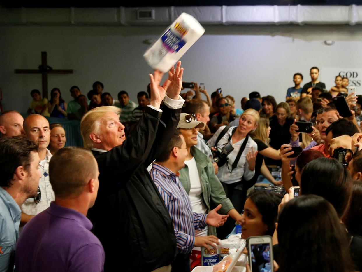 US President Donald Trump tosses rolls of paper towels to people at a hurricane relief distribution centre at Calvary Chapel in San Juan: Jonathan Ernst/Reuters