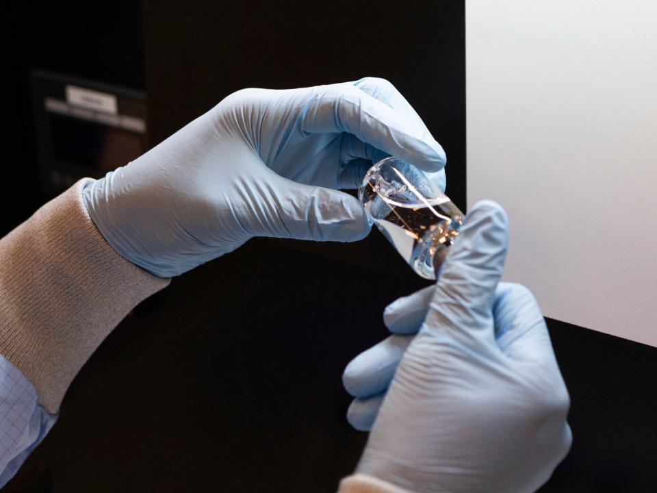 In this March 2020 photo provided by Gilead Sciences, a vial of the investigational drug remdesivir is visually inspected at a Gilead manufacturing site in the United States. Given through an IV, the medication is designed to interfere with an enzyme that reproduces viral genetic material. (Gilead Sciences via AP)