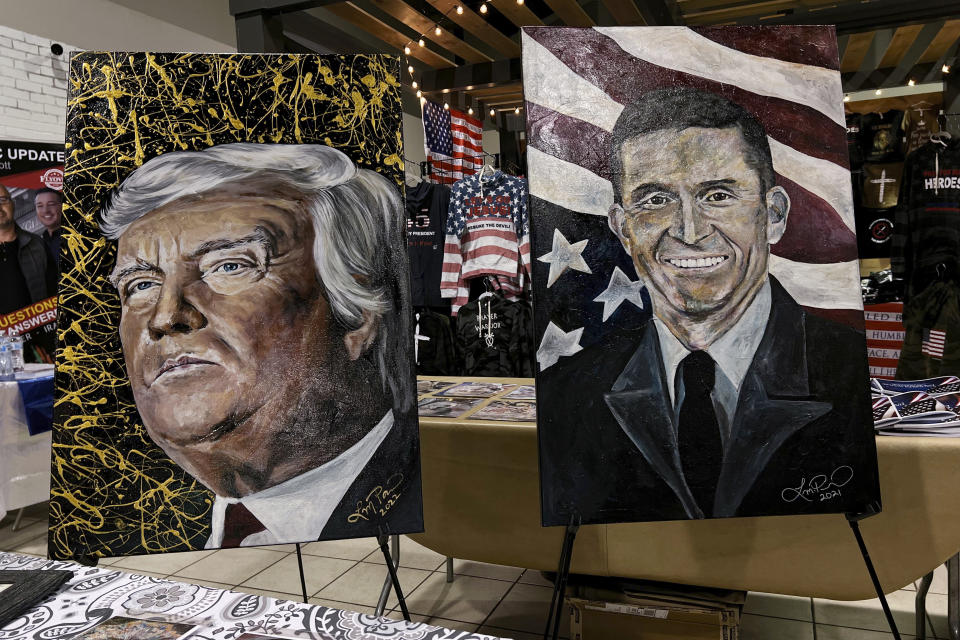 Paintings of former President Donald Trump and Michael Flynn, a retired three-star general who served as Trump's national security adviser, are displayed in a vendor area during the ReAwaken America tour at Cornerstone Church, in Batavia, N.Y., Friday, Aug. 12, 2022. (AP Photo/Carolyn Kaster)