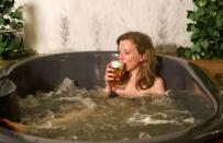 Customers enjoy a beer while relaxing in a jacuzzi full of hot water and a mixture of ingredients used to make beer at the Good Beer Spa in Brussels