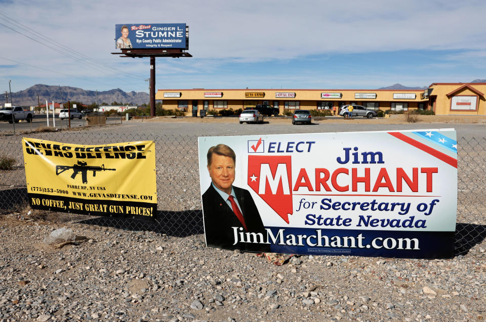 A billboard for Nevada Republican secretary of state candidate Jim Marchant is attached to a fence beside an advertisement for a gun shop on November 05, 2022 in Pahrump, Nevada. / Credit: Mario Tama / Getty Images