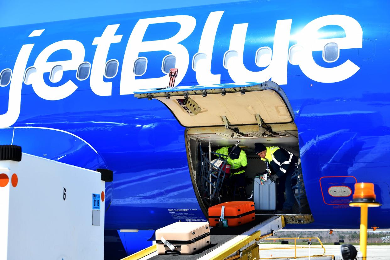 Ground crew removes baggage from a Jet Blue jet at Worcester Regional Airport.