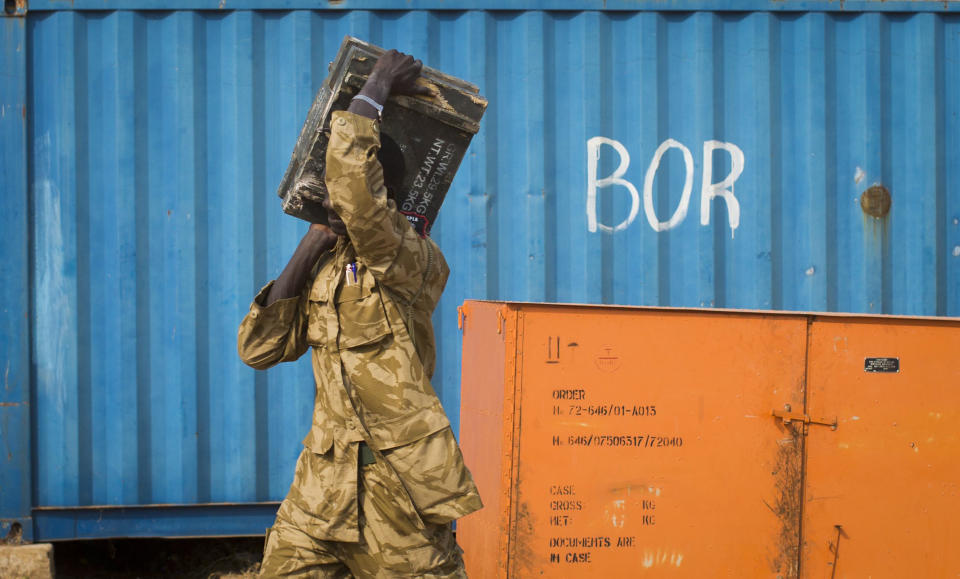 A South Sudanese government soldier carries an ammunition box from storage at the airport in Bor, Jonglei State, South Sudan Sunday, Jan. 19, 2014. Leaders for warring sides in South Sudan's monthlong internal conflict say they are close to signing a cease-fire and the South Sudanese military spokesman said that army forces had retaken the key city of Bor Saturday, defeating 15,000 rebels. (AP Photo/Mackenzie Knowles-Coursin)